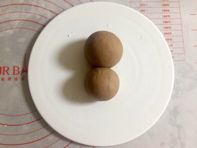 萌萌哒小猴子奶黄包,同样的方法再包一个奶黄包,包入20克左右的馅,稍微大一点。两个奶黄包放在一起,大的做脑袋,小的做身体。