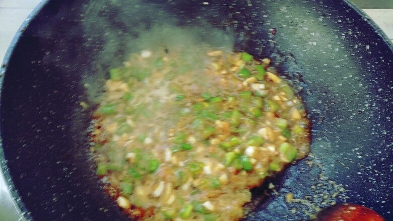 鱼香豆腐,放入葱蒜,倒入刚调好的汁,并勾入淀粉