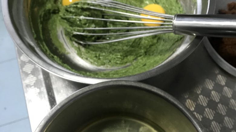 红糖菠菜泥戚风蛋糕,这时把蛋黄和蛋白分开,蛋黄直接放在面糊中,我釆用的分蛋法是直接用蛋壳倒过来倒过去的方法