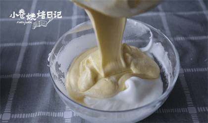 轻轻松松就能做出不开裂不坍塌的轻乳酪蛋糕,取1/3蛋白入奶酪糊盆,翻拌均匀,再将奶酪糊倒进蛋白霜盆中,翻拌均匀。