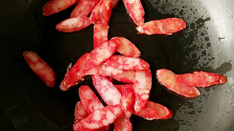 腊味荷兰豆,另起锅放少许油烧热后,放入腊肠小火煸炒至透明。
