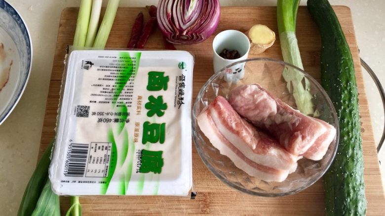 给回锅肉找个伴儿➕回锅豆腐回锅肉,食材合照:<a style='color:red;display:inline-block;' href='/shicai/ 5222'>卤水豆腐</a>一盒(我用了大概2/3),<a style='color:red;display:inline-block;' href='/shicai/ 428'>五花肉</a>180g,(上次买的<a style='color:red;display:inline-block;' href='/shicai/ 428'>五花肉</a>回家才发现超市阿姨称肉时竟然把肉皮给我去掉了,郁闷,还剩下两块今天一起用掉了)<a style='color:red;display:inline-block;' href='/shicai/ 54'>黄瓜</a>一根,<a style='color:red;display:inline-block;' href='/shicai/ 138'>大葱</a>葱白一段,<a style='color:red;display:inline-block;' href='/shicai/ 37'>姜</a>一块,<a style='color:red;display:inline-block;' href='/shicai/ 700'>花椒</a>适量,<a style='color:red;display:inline-block;' href='/shicai/ 29'>洋葱</a>半颗,<a style='color:red;display:inline-block;' href='/shicai/ 86474'>干辣椒</a>四颗,<a style='color:red;display:inline-block;' href='/shicai/ 3349'>蒜苗</a>三根。还用了一颗鸡蛋,忘记拍了