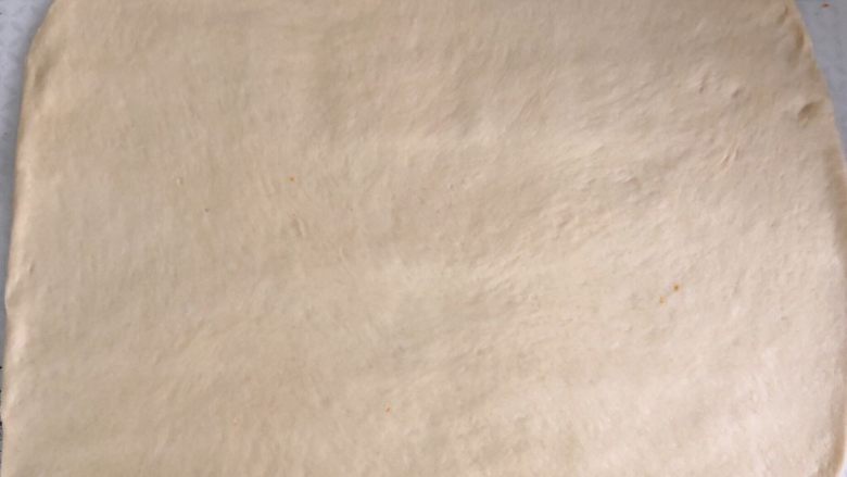 橙香肉桂面包卷,压扁后用擀面杖擀成40*40公分大的面片,厚度约为7、8mm。