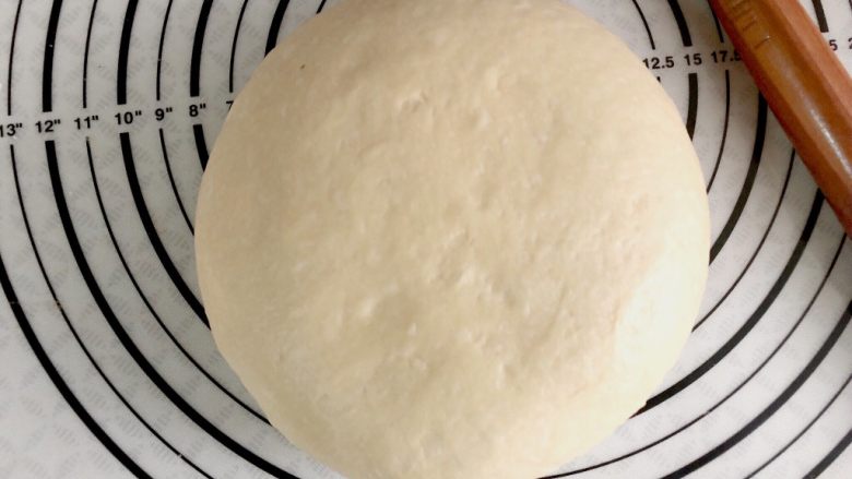 橙香肉桂面包卷,取出面团,揉匀,充分排气。盖保鲜膜醒15分钟。