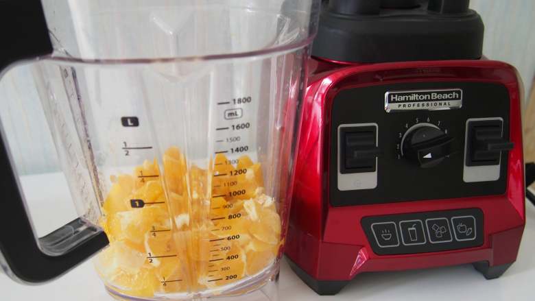 胡萝卜蜜橙汁,将切好的橙子放到料理杯中