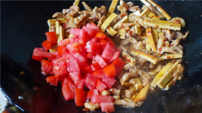 韭菜炒豆腐干,继续翻炒至豆腐干变软,加入番茄翻炒。