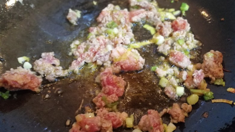 蛋裹肉碎炒蒜薹,锅内放油烧热倒入肉碎,葱花。