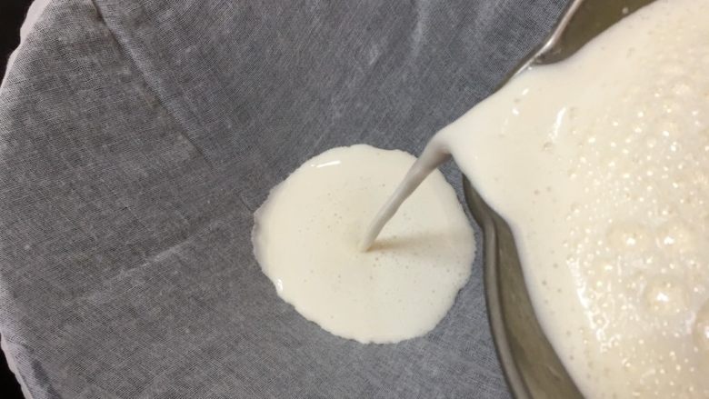 豆腐脑~电饭煲版,把打好的豆浆用纱布过滤出豆渣