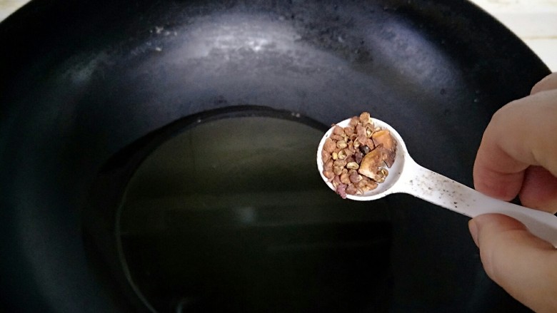 香焖鲅鱼干,锅中放油,加入花椒爆香捞出。