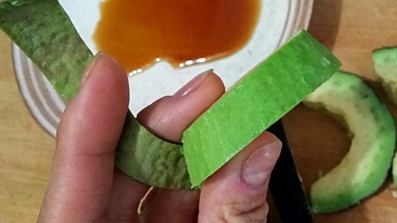 牛油果刺身,将牛油果外皮撕掉。成熟的牛油果非常容易去皮,并且果肉细腻爽滑。