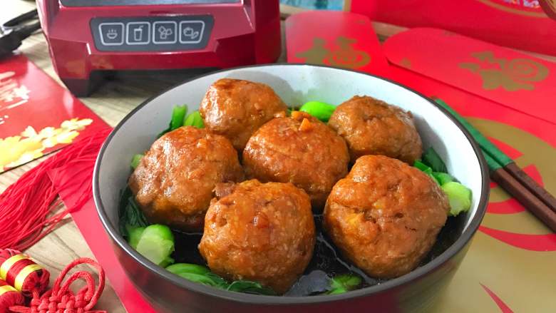 红烧狮子头,出锅放入铺了小青菜的盘中。