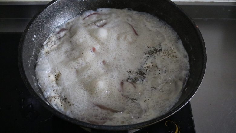 奶油蘑菇浓汤,将汤煮开后再继续煮10分钟左右;加入适量盐、黑胡椒、罗勒叶进行调味;