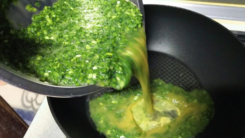 春游食谱~韭菜煎蛋,倒入准备好的韭菜鸡蛋液。
