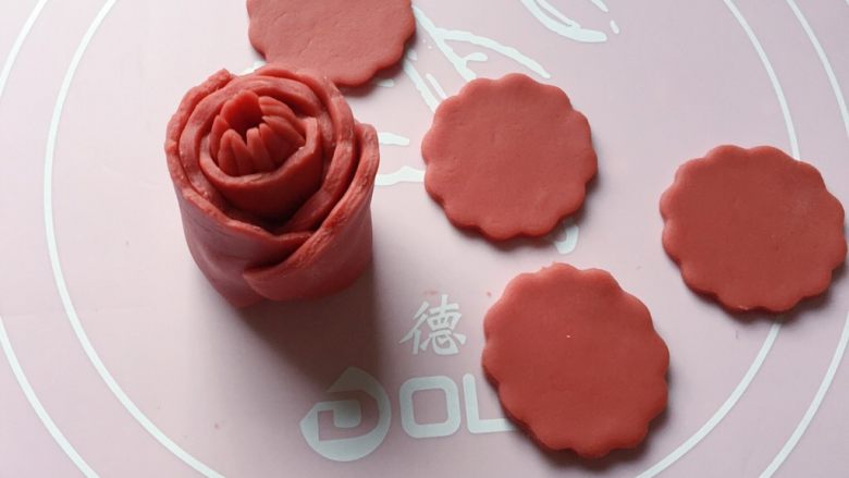红花馒头,如图:把第一片花瓣稍微拉长,粘贴在花苞上。
