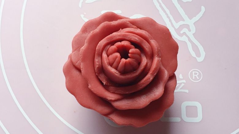 红花馒头,如图:依次将剩下的4片花瓣都粘贴在花苞上,稍微整理下,一朵漂亮的红花就做好啦。