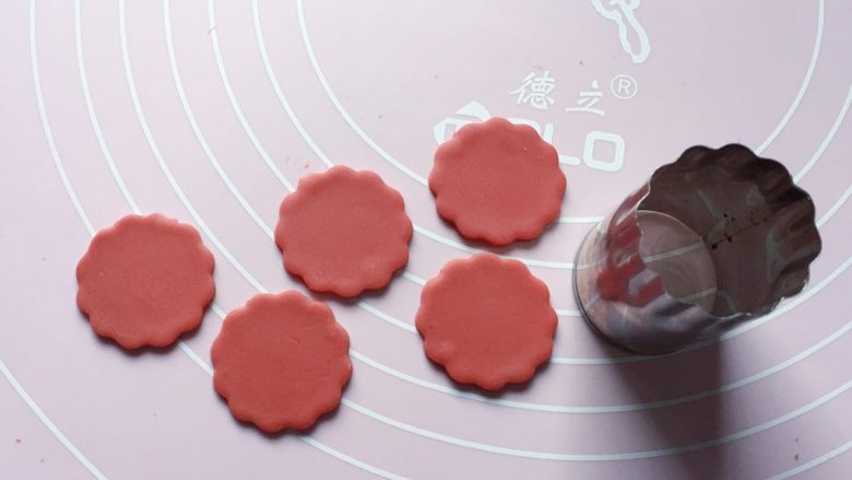 红花馒头,如图:再取一面团擀成2mm厚的面片,用3.8厘米的蔬菜切花模压出5片花瓣。