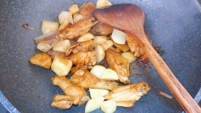 可乐土豆烧鸡翅,倒入土豆块,翻炒片刻