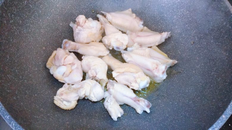 可乐土豆烧鸡翅,锅内倒入油,把鸡翅放入锅中煎一下
