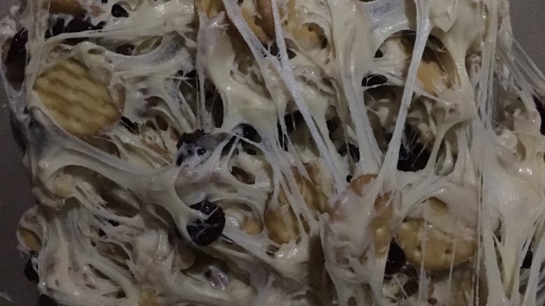 网红雪花酥-烤箱版,戴手套后,一直不停的把上面的糖往下翻,如果饼干比较多,一定要多翻一会,直到饼干被千丝万缕的包裹住