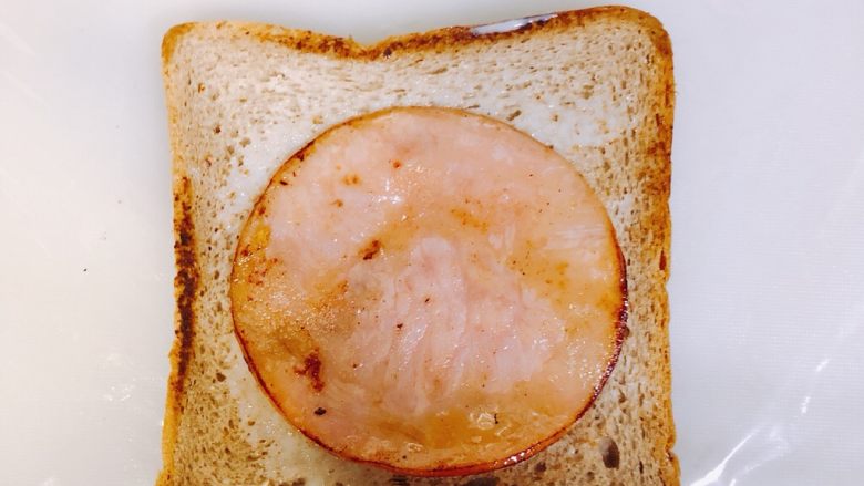 全麦三明治,放一张保鲜膜在底下，然后一块面包刷<a style='color:red;display:inline-block;' href='/shicai/ 893'>炼乳</a>放上煎好的火腿