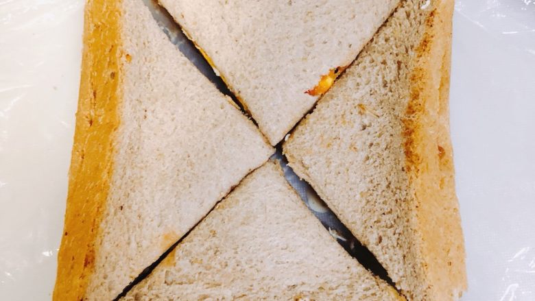 全麦三明治,打开保鲜膜，用刀对角切下去