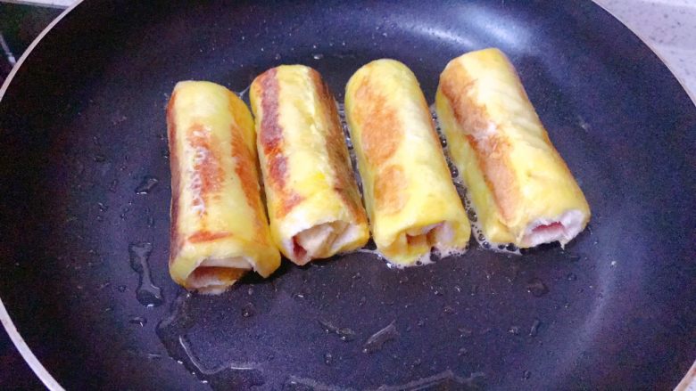 香蕉吐司卷,不断翻转,使每一面都煎至金黄