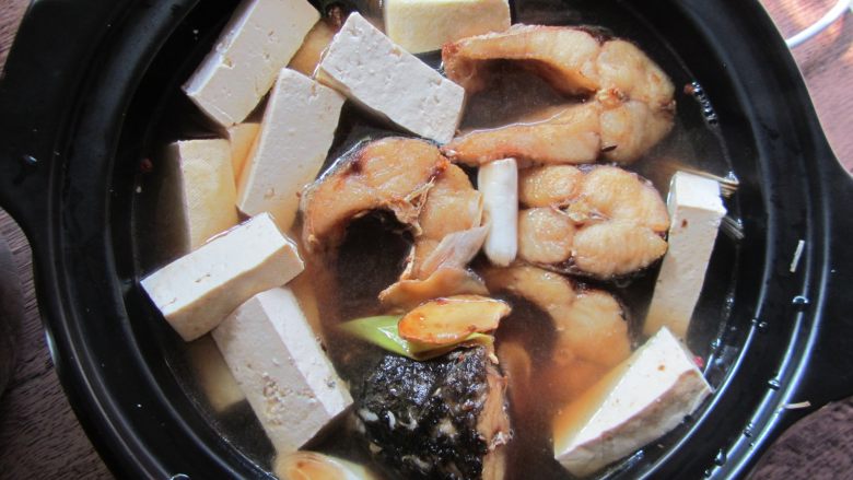 砂锅鱼炖豆腐,加入鱼块、豆腐、炒好的酱汁(不要多,和鱼块持平即可)、料酒、白糖加盖炖煮