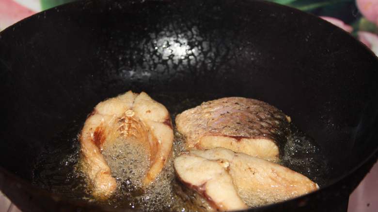 砂锅鱼炖豆腐,腌好的鱼放入热油中炸至表面金黄备用(鱼炸以前要用厨房纸喜欢干表面水分)