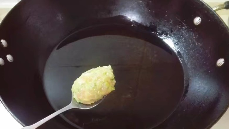 青皮萝陀子,锅中放入适量食用油烧开,用勺子取出一勺肉馅在盆里壁滚动至表面光滑,放入锅中