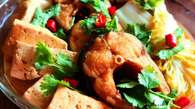 砂锅鱼炖豆腐,取出摆盘,点缀香菜和红椒即可
