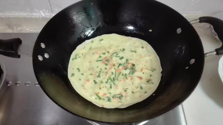 摊香葱萝卜末鸡蛋饼,看到鸡蛋面糊表面快凝固