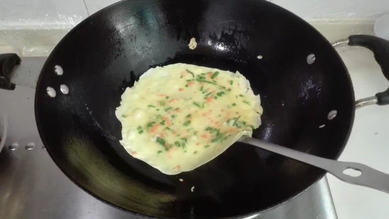 摊香葱萝卜末鸡蛋饼,用锅铲翻面煎黄就行