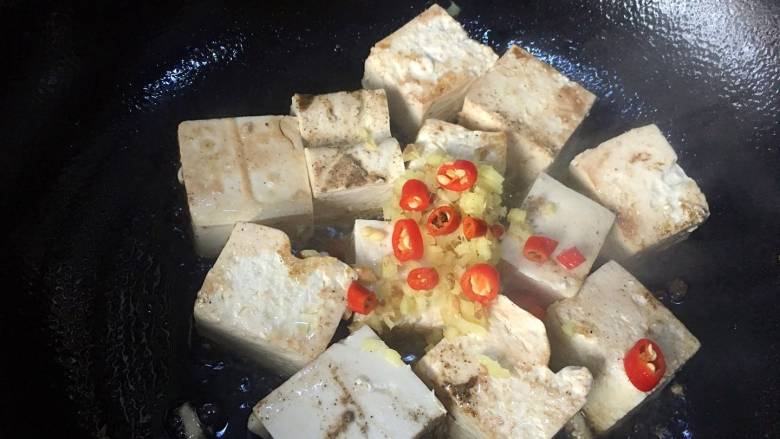 可乐烧豆腐,撒入姜末和红椒圈,爆出香味(红椒不要放完,留下一点最后用来点缀);