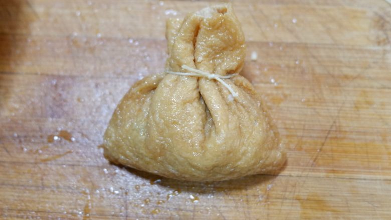 卡通小熊豆腐糯米包便当,找一根包粽子的棉线,将豆腐包绑起来。