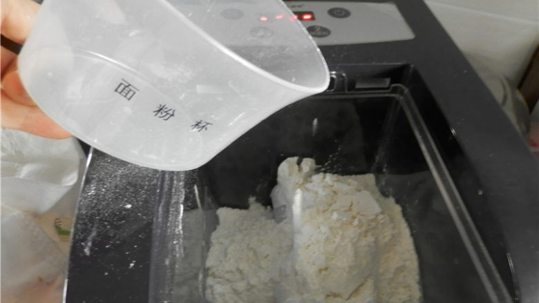 自制车前草面条,用专用面粉量杯倒入两平杯<a style='color:red;display:inline-block;' href='/shicai/ 550'>高筋面粉</a>在搅拌桶(清洁刮刀将面粉刮平)。