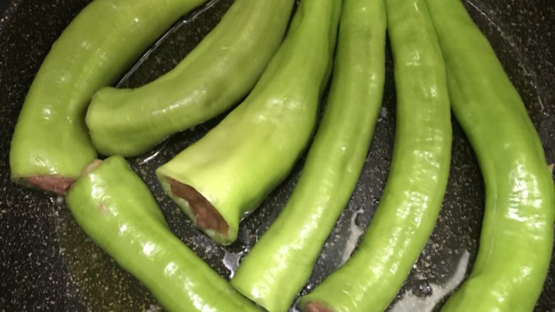 虎皮尖椒酿肉,油温七成热时下尖椒,可以用中火煎