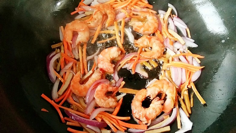 泰式帕泰Pad Thai,锅中倒入适量的<a style='color:red;display:inline-block;' href='/shicai/ 851'>橄榄油</a>,烧至7成热后加入虾,洋葱,胡萝卜和豆干煸炒,炒至虾变红。