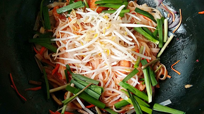 泰式帕泰Pad Thai,加入一半的<a style='color:red;display:inline-block;' href='/shicai/ 133'>绿豆芽</a>和韭菜。翻炒一下断生。