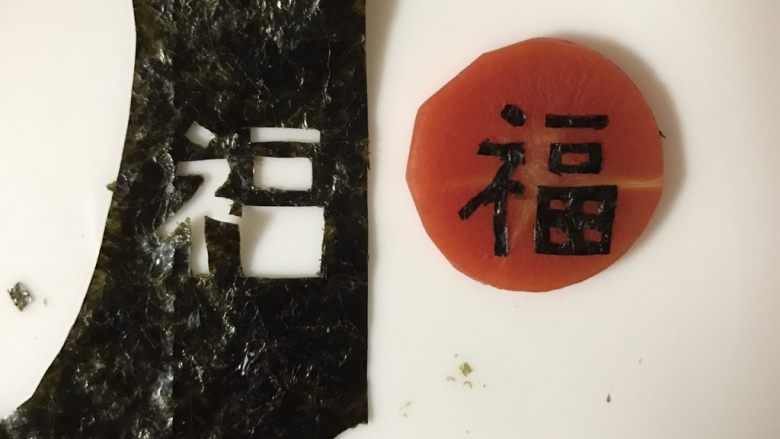招财猫便当/饭团,取一片海苔,用刻刀刻出福字,贴在胡萝卜片上