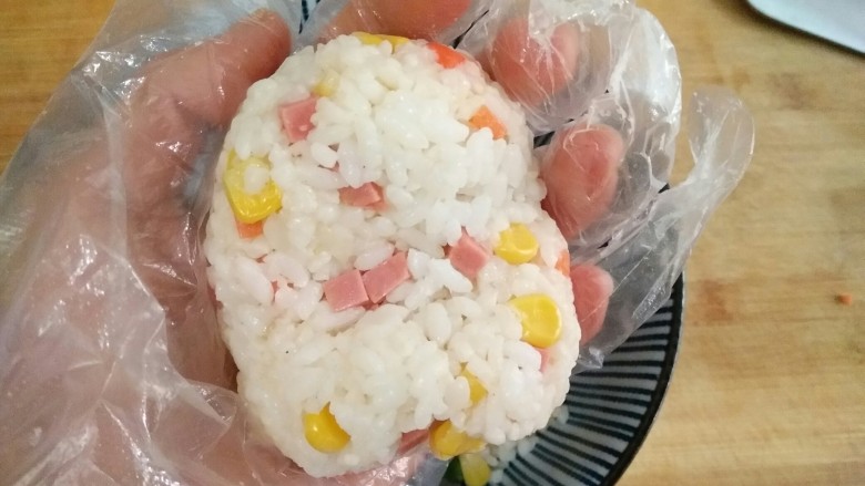 泰迪饭团,将抓拌好的米饭团成饭团,整整形,做成泰迪的脸。