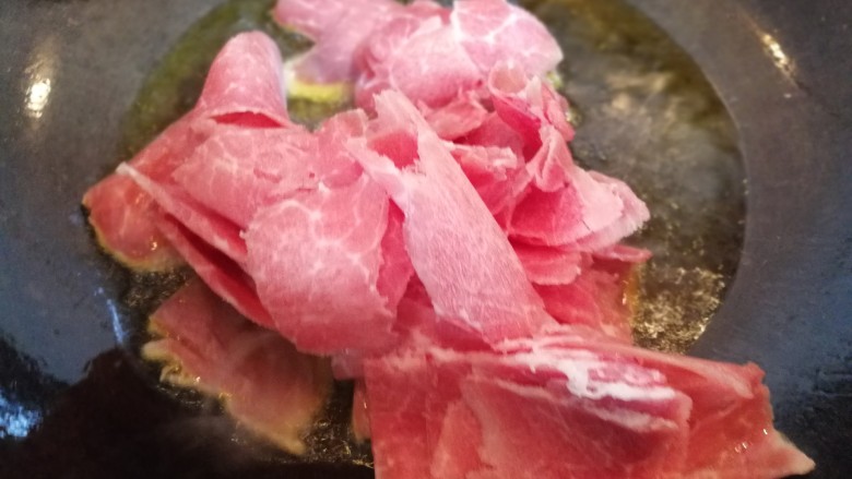农家小炒の小毛葱炒肉,将姜丝,肉片放入锅中翻炒。