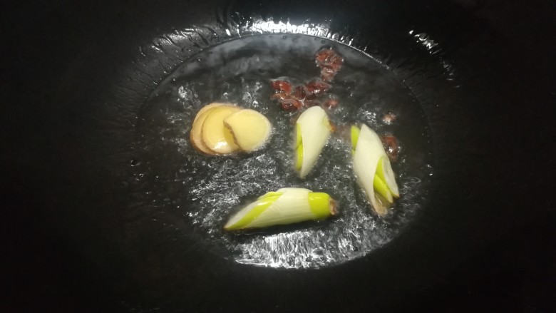 啤酒烩鸡翅,大勺内放入两匙食用油,油温六成热时放入葱段,姜片和<a style='color:red;display:inline-block;' href='/shicai/ 695'>八角</a>煸炒出香味。