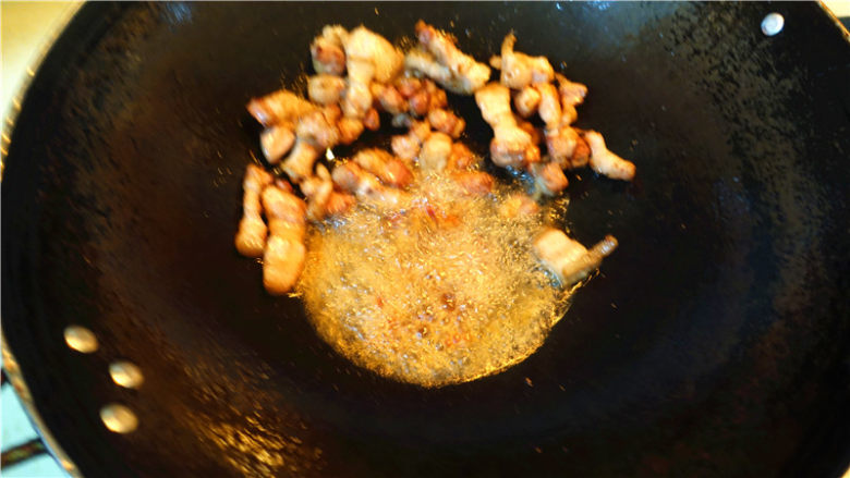 茄子甜椒烧五花肉,将五花肉推到锅边,放一大勺豆瓣酱在底油里炒香。
