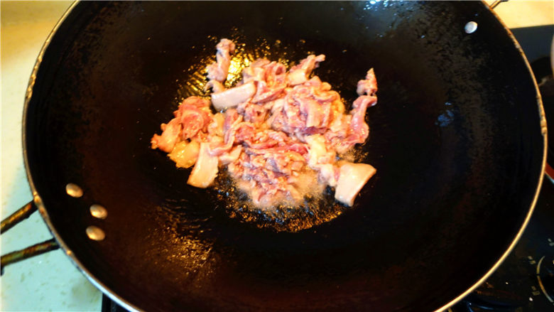 香菇大蒜炒肉,将肉片放入锅里,翻炒。