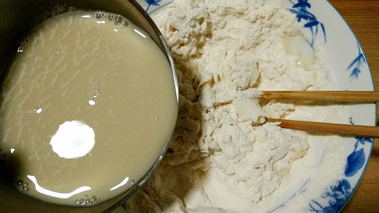 向日葵馒头,酵母粉用温水冲开少量多次加入面粉中,用筷子搅拌成雪花状,和成面团。