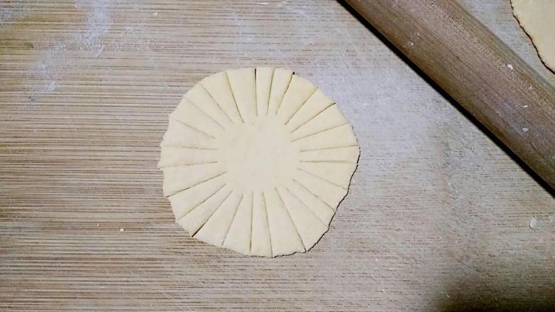向日葵馒头,将南瓜剂子压扁擀成饺子皮大小的圆饼,薄厚保持均匀一致,大概3-4mm。