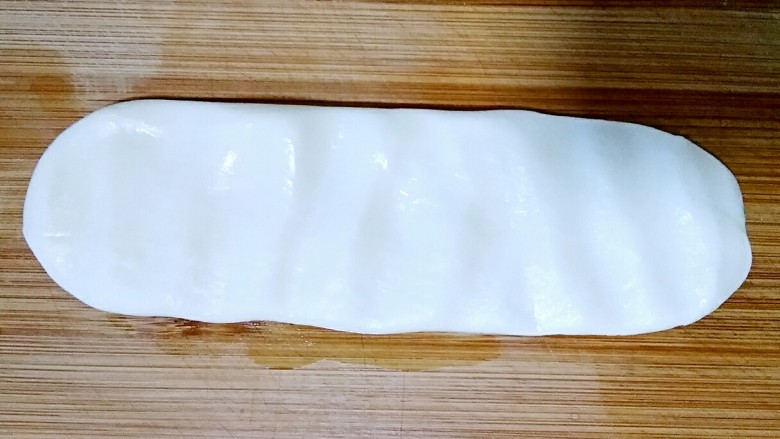 一碗看馋万人的油泼面,取一条面,在案板上按扁。