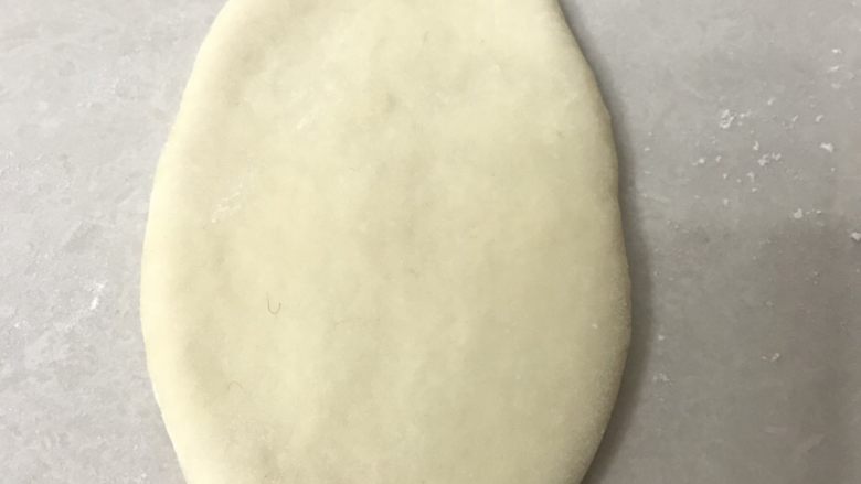 葱香芝士肉松排包,取一面团拍扁用擀面杖从中间向两头擀成开,边上的气泡用手拍掉,翻面继续擀一下,稍微作整理