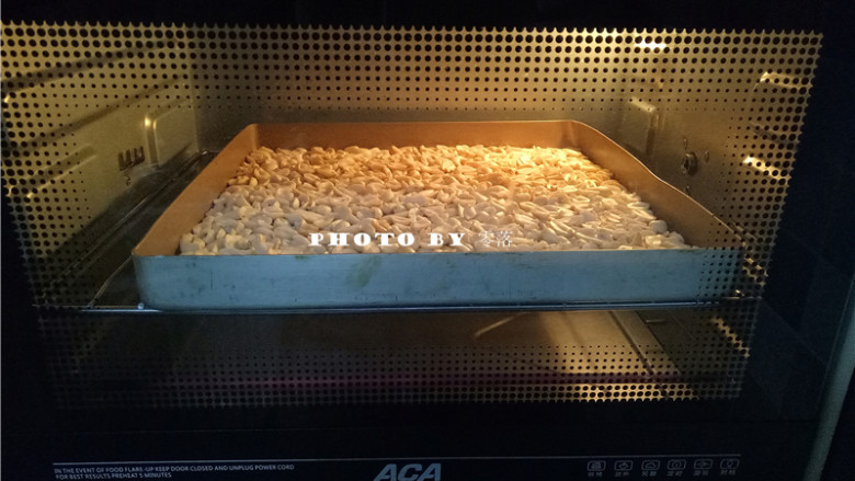 椰香牛轧糖,制作牛轧糖时,再将花生倒入烤盘,放入烤箱保温,温度设置为上下火100度,烘烤时间为20分钟;有温度的花生可与棉花糖等材料快速融合;