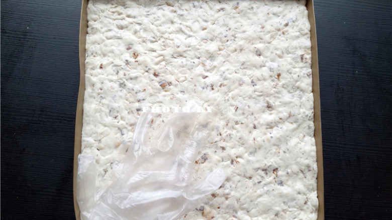 椰香牛轧糖,将牛轧糖从锅里倒出来,戴上食品级手套反复揉,便于散热;然后铺满烤盘,压实按平;